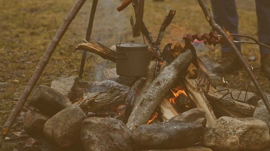 metal pot burning on campfire